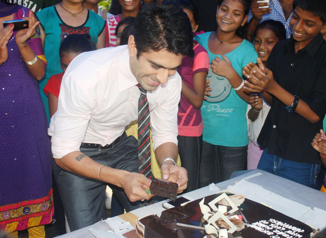 Eijaz Khan cut a cake with children from an NGO