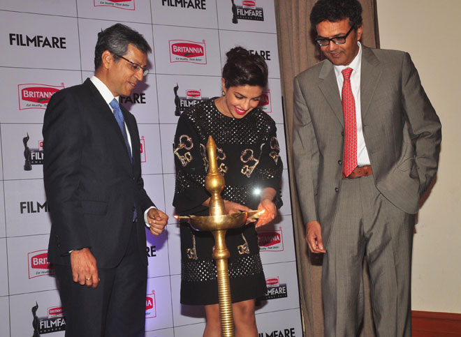 Mr. Tarun Rai (CEO, WWM), Priyanka Chopra receiving a Britannia gift hamper from Mr. Varun Berry (MD, Britannia Industries) while lighting diya